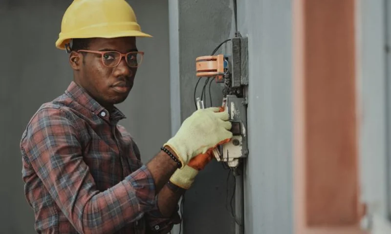Electrician pulling wire through a wall opening